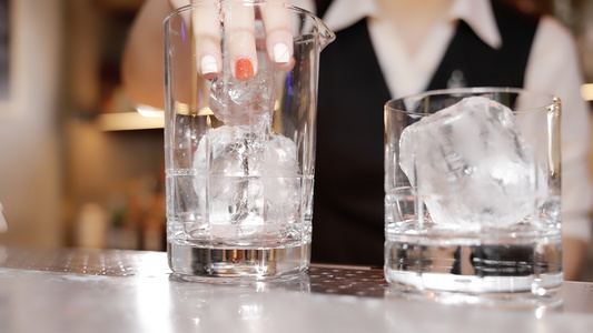 调酒师将冰块放入玻璃杯[冻结成]视频