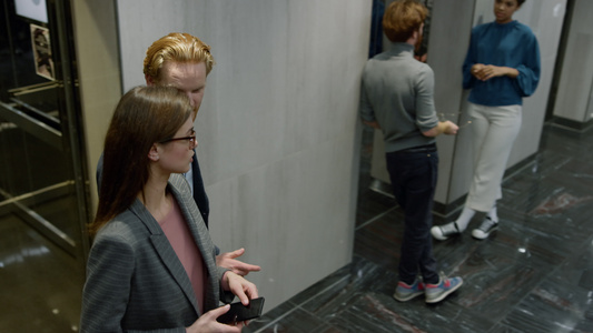商务人士和女在电梯汽车上交谈同事下电梯后车视频
