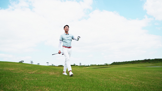 年轻男性拿着高尔夫球杆走在球场上[二十多岁]视频