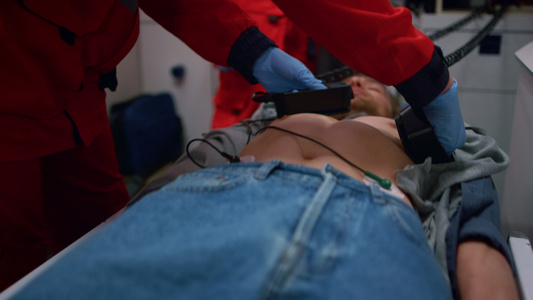 急救车驾驶员手用除颤器对人做阴性移植手术视频