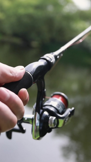 钓鱼的手部及渔轮特写金属纺车轮16秒视频