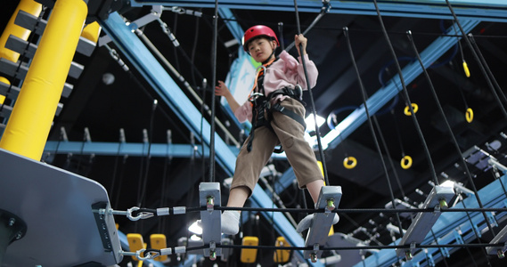 男孩在室内游乐场玩高空探险项目视频