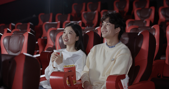 电影院中边吃零食边看电影的情侣视频