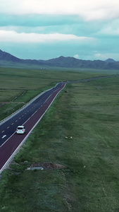 航拍新疆自驾游赛里木湖风景区私家车行驶在公路上视频