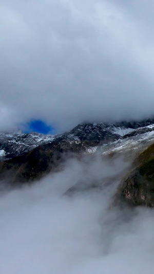 无人机穿过云层航拍云端之上的雪山壮丽景观36秒视频