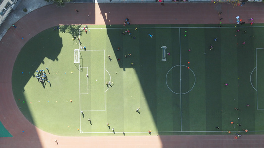 航拍校园阳光足球场上体育课的学生4k素材视频