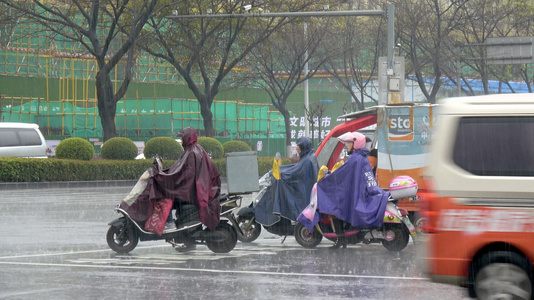 下雨天骑着电单车路口等待红绿灯的人们视频