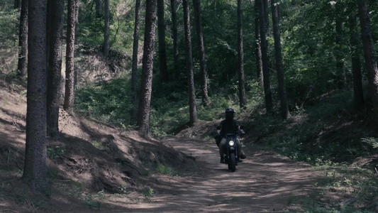 男子在森林山路上骑摩托车视频