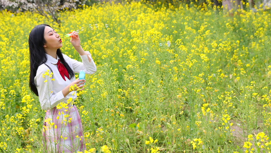 女生在油菜花田吹泡泡[真好玩]视频