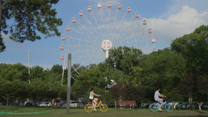 城市蓝天白云晴朗天空摩天轮下休闲娱乐的行人街景4k素材72秒视频