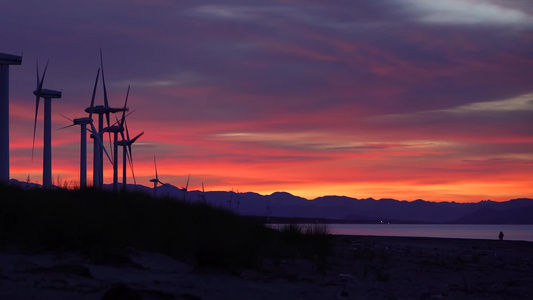 唯美夕阳日落沙滩风力发电新能源风车视频