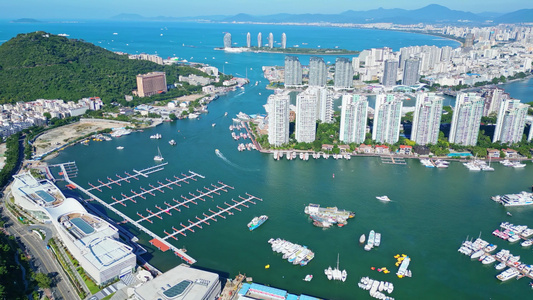 高视角航拍鸟瞰海南三亚三亚湾城市风景蓝天白云建筑游艇码头凤凰岛全景海岸线航拍视频