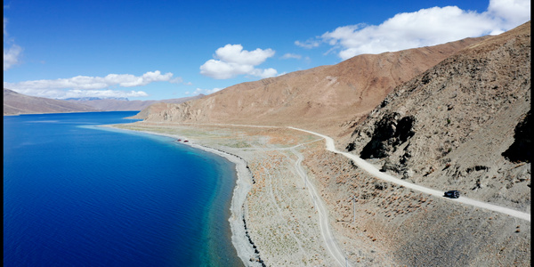 8K航拍西藏地区羊卓雍措羊湖自驾小车行驶蓝天白云视频