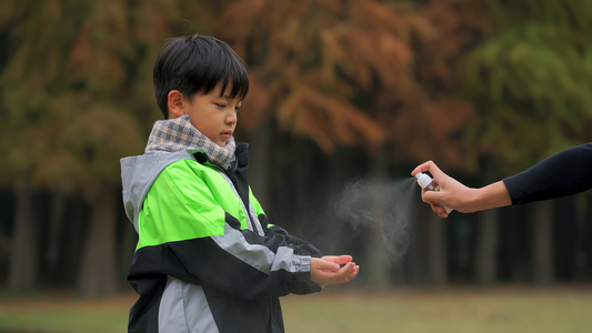 4K秋冬季节小男孩疫情期间广公园手部消毒视频