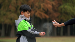 4K秋冬季节小男孩期间广公园手部消毒5秒视频