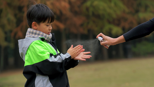 4K秋冬季小男孩疫情期间逛公园手部消毒[遛弯儿]视频