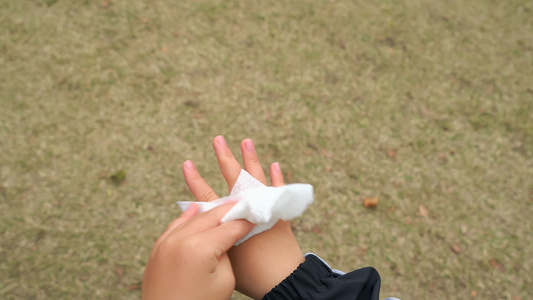 4K秋冬季节户外小男孩使用纸巾擦拭手部视频