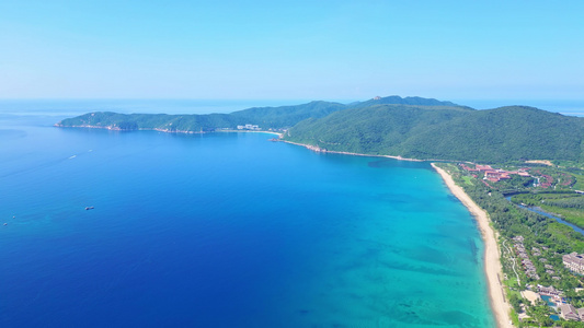 航拍海南三亚亚龙湾蔚蓝色海洋海岸线背景与游艇风光视频