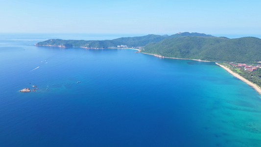 航拍海南三亚亚龙湾蔚蓝色海洋海岸线背景与游艇风光视频