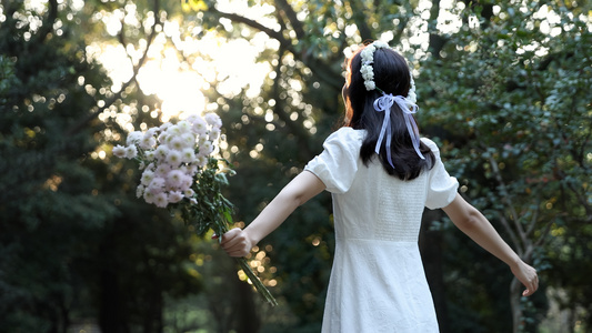 女孩闻着手捧着的花香翩翩起舞视频