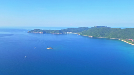 航拍海南三亚亚龙湾蔚蓝色海洋海岸线背景与游艇风光视频