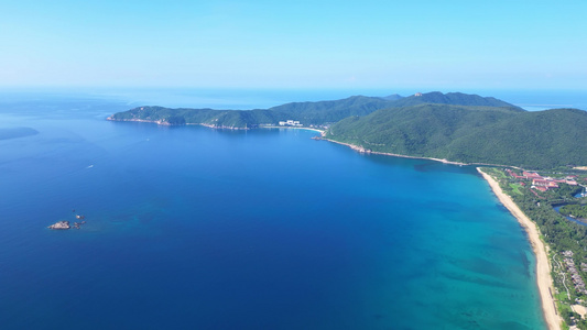 航拍海南三亚亚龙湾蔚蓝色海洋海岸线背景与游艇风光视频