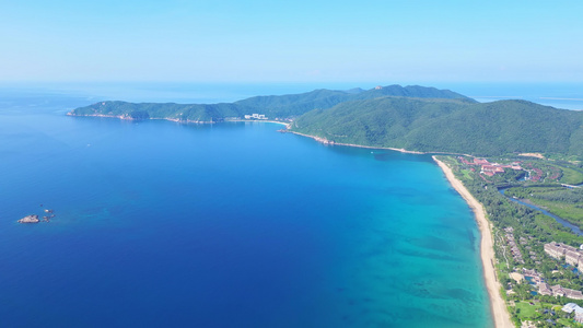 航拍海南三亚亚龙湾蔚蓝色海洋海岸线背景与游艇风光视频