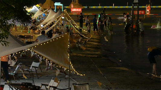 城市海滨夜景沙滩浴场冲浪人群帐篷休闲娱乐街景4k素材视频