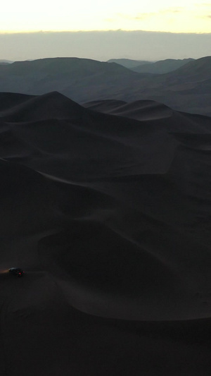 日出前在沙漠中行驶的汽车航拍视频阿拉善盟58秒视频