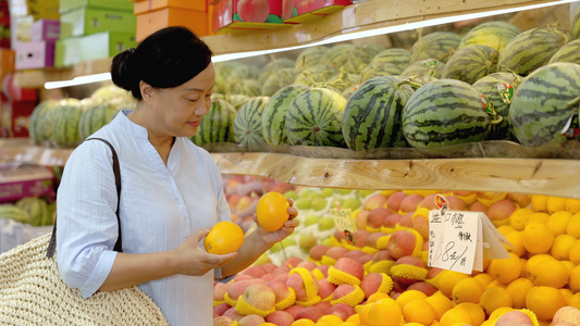 大妈在水果店挑选橙子视频