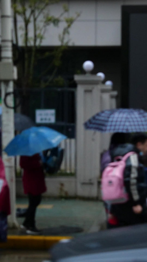 学校小学生放学父母接送学生雨中学生空境学校门口25秒视频