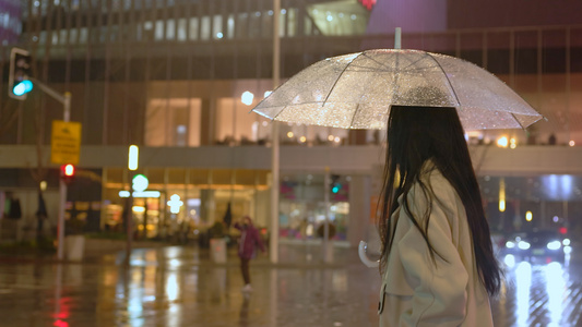 夜晚女人撑伞通过路口视频