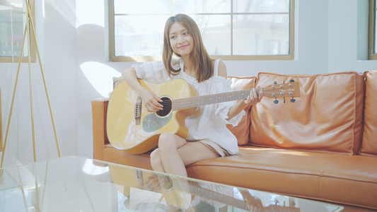 4K女生在沙发上弹吉他视频
