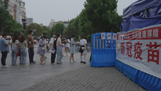 【该视频无肖像权，请勿商用】城市街头街景排队等候注射新冠疫苗的人群健康医疗4k素材视频