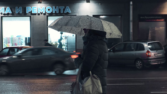 寒冬下雨天城市街边撑伞等待公交车的人视频