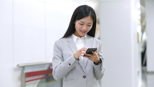 4k穿白领的上班女性在玩手机视频