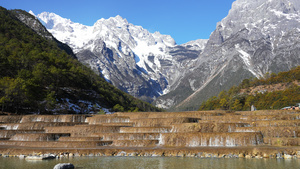 航拍云南5A级旅游景区玉龙雪山冰雪融化成的溪流4k素材65秒视频