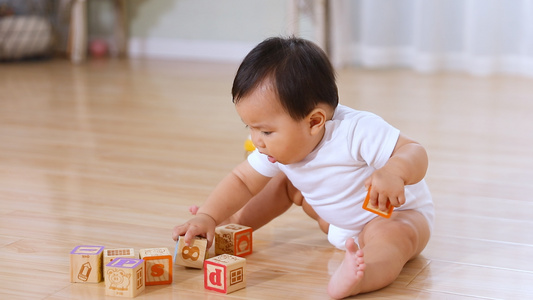 小宝宝坐在地板上玩益智积木视频