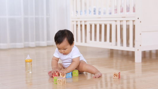 小宝宝坐在地板上玩益智积木视频