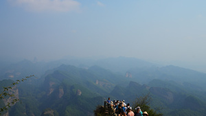 航拍湖南5A级旅游景区崀山山顶欣赏风景的拥挤人群4k素材60秒视频