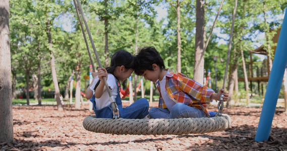 两个小孩子面对面开心荡秋千视频