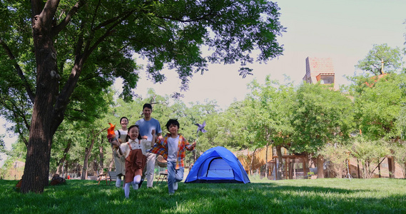 一家四口露营在草地上开心奔跑视频