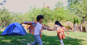 两个孩子在草地上手拉手开心转圈做游戏10秒视频