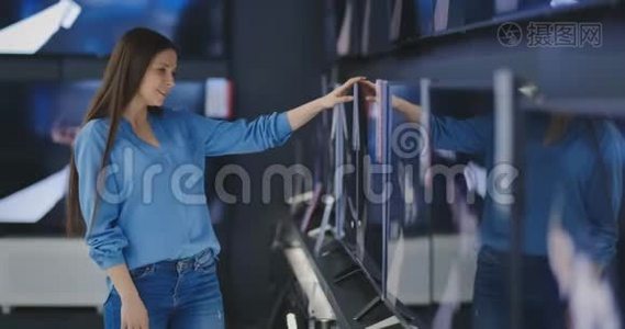 智能现代女性客户选择大型电视机在电子商店。 新的银幕时代。视频