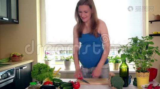 怀孕和营养。 孕妇在厨房的餐桌上切辣椒蔬菜视频
