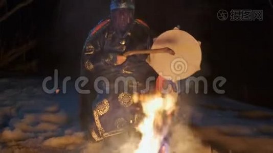 萨满坐在火旁敲鼓。视频
