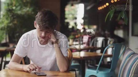 年轻人用手机上网，方便触摸，在咖啡馆发送短信。 帅哥在里面聊天视频