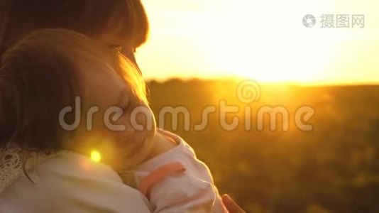 小孩子抱着妈妈睡着了，夏天在公园里夕阳西下，慢悠悠地走着妈妈和女儿视频