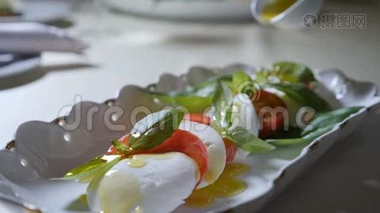 健康食品和素食理念.. 把橄榄油倒入卡普雷斯沙拉。 意大利辣椒色拉和视频