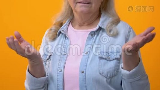 沮丧的祖母用手指着黄色的背景，消极的反应视频